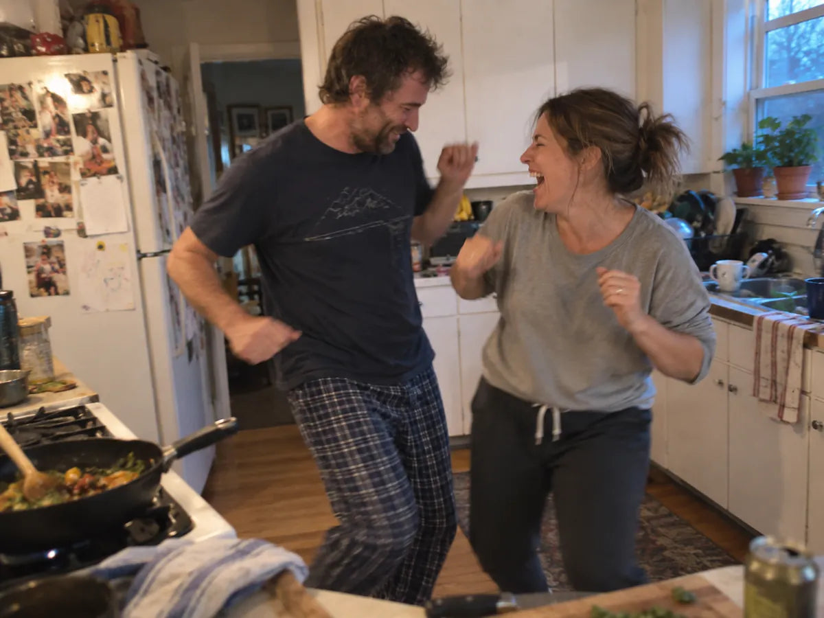 A couple dancing and laughing in their kitchen